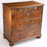 A George I walnut and pine chest of drawers, the rectangular top above two short and three long