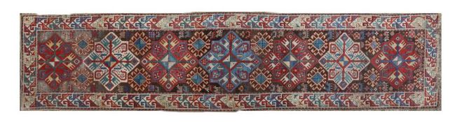 A large Caucasian Kazak runner rug, having a brown ground and cream ground set with six main guls