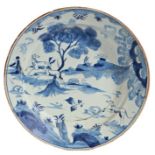 An 18th Century delft charger, the central field decorated with a stag and doe pursued by a hound,