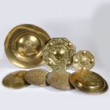 A collection of 17th Century and later brass ware, to include an alms dish, warming pan lids, a wall