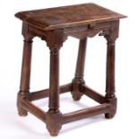 A 17th Century joint stool, formally a table stool, the rectangular top above bicuspid shaped