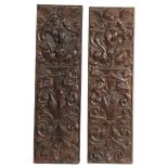 A pair of 18th Century carved oak panels, decorated with cherubs and putti amongst foliate