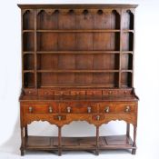18th Century oak dresser base, the later associated rack with concave cornice above an apron and