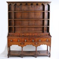 18th Century oak dresser base, the later associated rack with concave cornice above an apron and