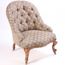 A Victorian button back chair, the arched back above a serpentine stuff over seat flanked by low