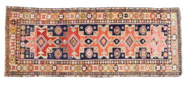 A Caucasian runner rug, Dagehstan, having a blue red and yellow ground set with five main guls and