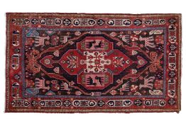 An Iranian rug, having a red and brown ground set with central motif set with animals and people,