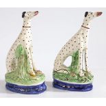 A pair of 19th Century Staffordshire dalmatians, modelled in seated positions, on blue and gilt line
