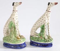 A pair of 19th Century Staffordshire dalmatians, modelled in seated positions, on blue and gilt line