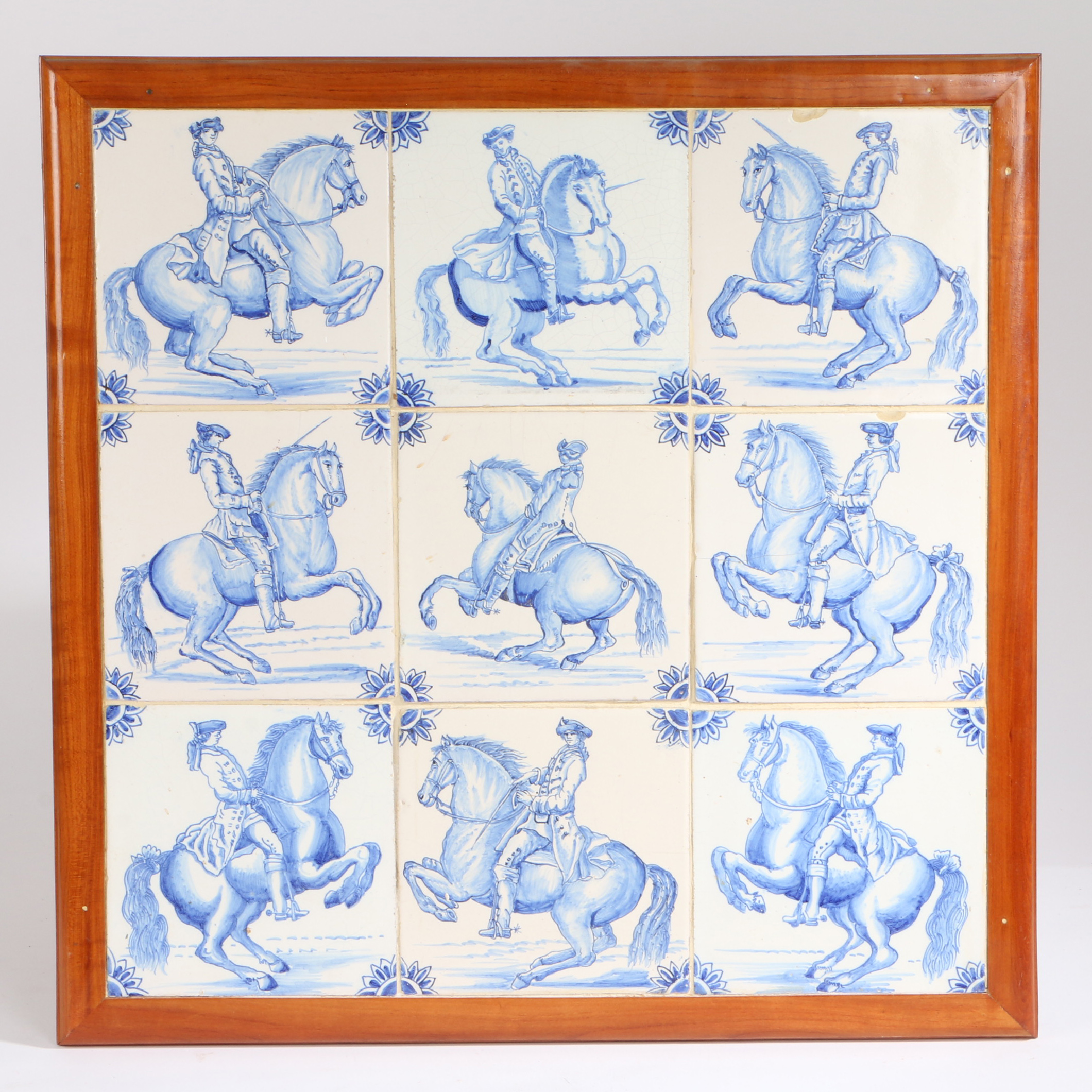 Nine 18th Century delft tiles depicting figures on horseback, housed in a pine frame, 51.5cm wide,