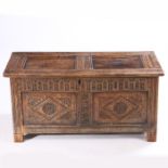 A 17th Century oak coffer, with a twin panel hinged top above a thumb craved frieze and two