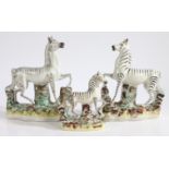A near pair of 19th Century Staffordshire zebras, 26cm high, together with a smaller Staffordshire