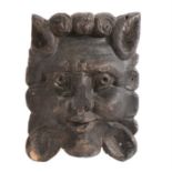 A 17th Century carved oak lion mask, with a humanesque face and flowing mane, 15cm wide, 20cm high