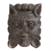 A 17th Century carved oak lion mask, with a humanesque face and flowing mane, 15cm wide, 20cm high
