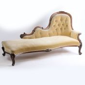 A Victorian mahogany chaise lounge, the foliate carved rail above a button back and stuff over