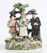 A 19th Century Staffordshire bocage "Tithe Pig" group, modelled as a farmer, his wife and baby