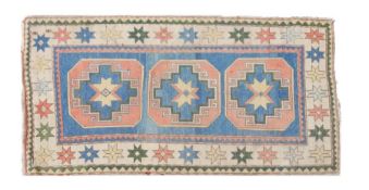 A Caucasian Kazak rug, with a blue red and cream ground set with three main memling guls together