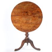 A George III fruit wood occasional table, the circular top above a turned column and cabriole