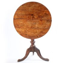 A George III fruit wood occasional table, the circular top above a turned column and cabriole