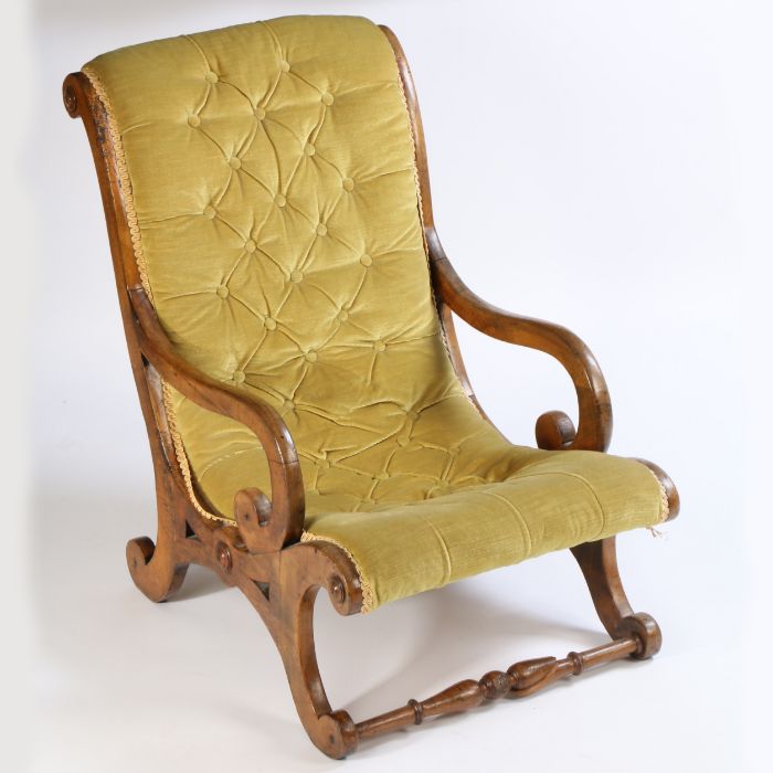 A Victorian mahogany button back low armchair, the sweeping arched back above curved arms and X