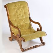 A Victorian mahogany button back low armchair, the sweeping arched back above curved arms and X