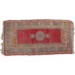 A South Persian rug, having a red and blue ground set with a central medallion together with