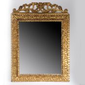 A gilt framed wall mirror, with pierced scrolled pediment and scroll decorated frame, 61cm wide,