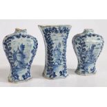 A garniture of three Delft blue and white vases, with raised foliate decoration and cartouches