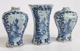 A garniture of three Delft blue and white vases, with raised foliate decoration and cartouches