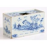 An 18th Century Delft flower brick, with Oriental landscape decorated front and back flanked by a