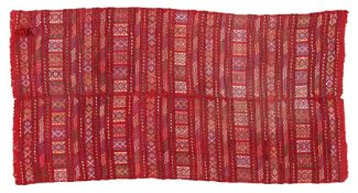 A Persian woollen rug, the red ground with horizontal deigns with tassel ends, 219cm by 115cm