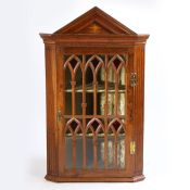 A hanging corner cabinet in the Gothic taste, the angled top above inlaid with a star and a door