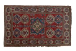 A Caucasian style rug, made in Pakistan, having hooked guls to the central field and multiple