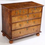 A George I walnut and boxwood strung chest of drawers, the rectangular top with swag inlay above two