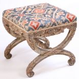 A 19th Century French giltwood foot stool, the stuff over top above acanthus scrolls and X frame
