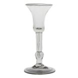 A mid 18th Century baluster wine glass, English circa 1730, the bell bowl with a long tear to the