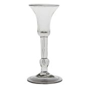 A mid 18th Century baluster wine glass, English circa 1730, the bell bowl with a long tear to the