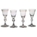 Four 18th Century Bohemian wine glasses, circa 1725-1750, with foliate engraved decoration above a