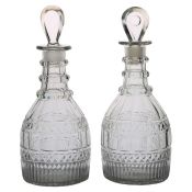 A pair of early 19th Century decanters, Anglo-Irish circa 1810, the associated stoppers above cut