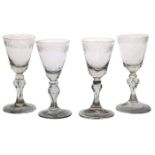 Four 18th Century Bohemian wine glasses, circa 1725-1750, with foliate engraved decoration above a