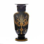 A late 19th Century Bohemian black glass vase, with a gilded floral drape design, probably by Moser
