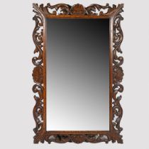 A 19TH CENTURY CARVED OAK WALL MIRROR.