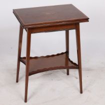 AN EDWARDIAN MAHOGANY AND INLAID FOLD OVER GAMES TABLE.