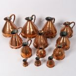 A COLLECTION OF THIRTEEN COPPER GRADUATING HAYSTACK JUGS, GILL TO 1 PECK.