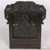 A HANGING CORNER CUPBOARD FORMED FROM A 17TH CENTURY OAK WAINSCOT CHAIR BACK.