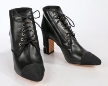 A pair of Chanel black leather lace-up pointed ankle boots with block heel and satin CC logo toe
