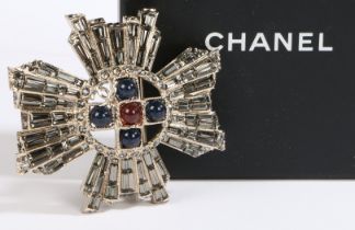 A Chanel brooch, of cross form with central red paste roundel surrounded by a cross of four blue