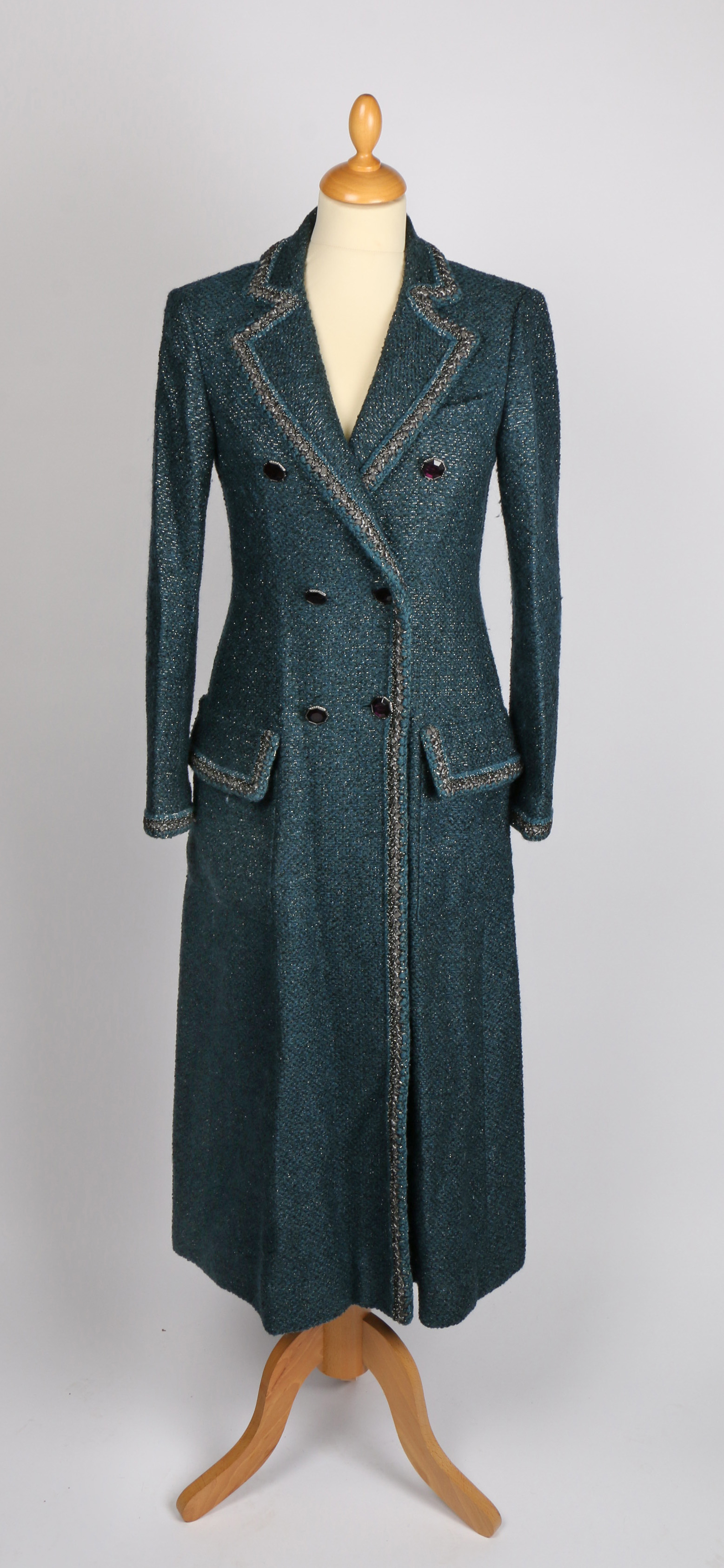 A Chanel forest green bouclé wool coat with bronze metallic trim and simulated amethyst buttons,