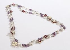 A Chanel necklace, with burgundy and cream enamel stylised flowerheads, interlocking Chanel C's,