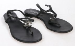 A pair of Chanel black leather flat toe-post sandals with chrome metal CC logo, size 36.